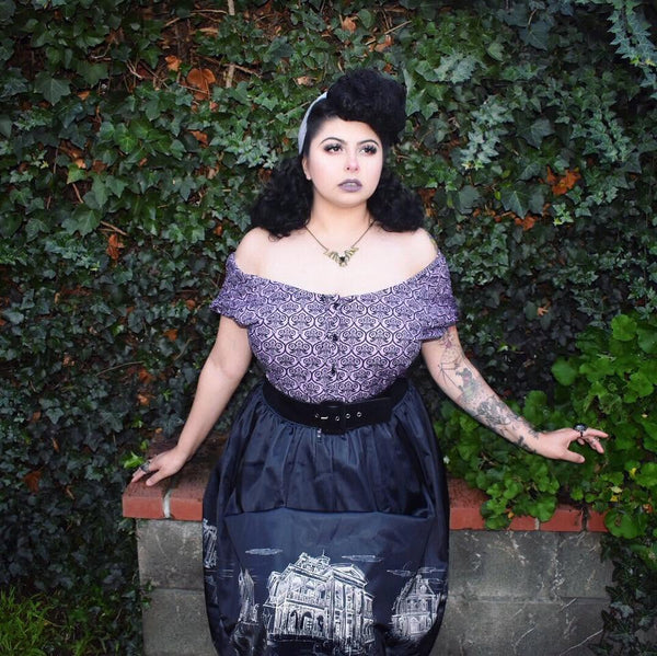 Model wearing Lil' Lou Lou's Mary Blouse in the Haunting Wallpaper print styled off the shoulders with a coordinating gothic-inspired skirt.