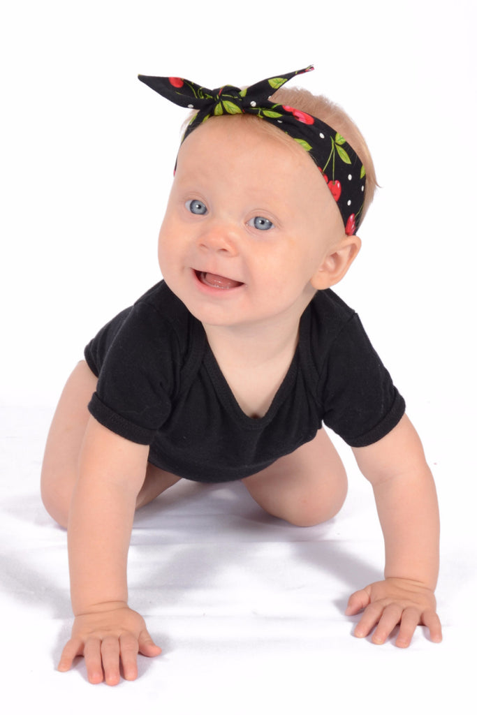 Baby wearing Lil' Lou Lou's Black Cherry Dots 3 in 1 baby headband with removable bow.