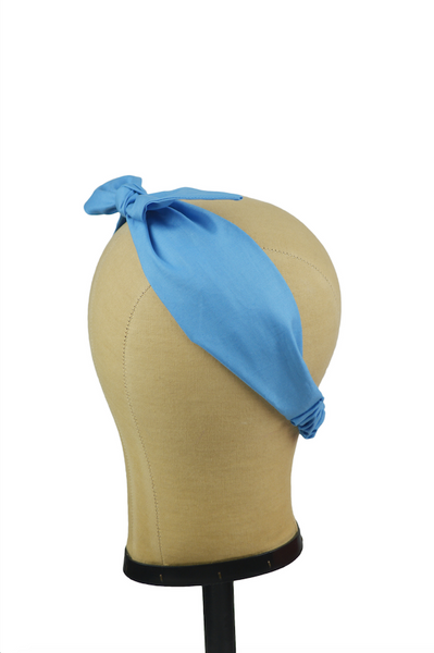 Blue 4 in 1 headband with removable bow shown from side view on mannequin head