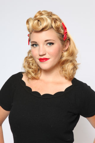 Model wearing two Classic Red Cute Knotted Bow hair clips styled with a vintage pin curls hairstyle and soft curls.