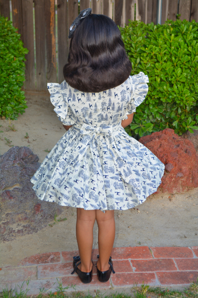 Back view of the vintage-inspired Gianna Dress for girls in the Queen of the Forest woodland print with adjustable waist ties tied in the back.