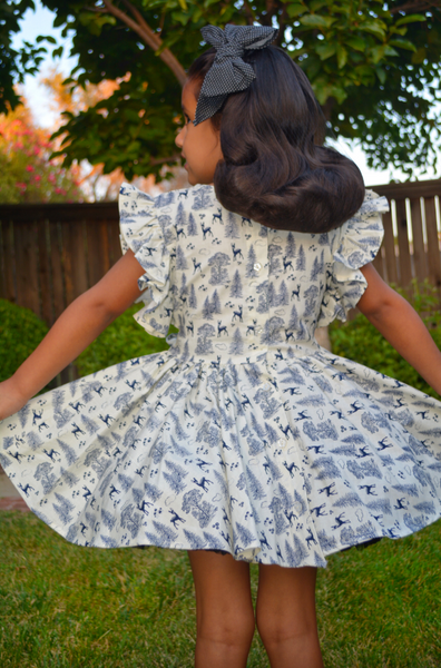 Back view of the Gianna Dress in the Queen of the Forest woodland print featuring a button-back closure, flutter sleeves, and twirl-worthy gathered skirt.