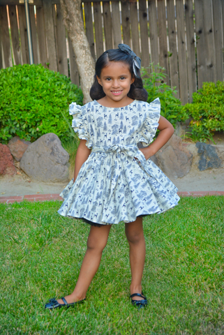Girl wearing Lil' Lou Lou's Gianna Dress in the Queen of the Forest woodland print featuring flutter sleeves and a vintage-inspired silhouette.