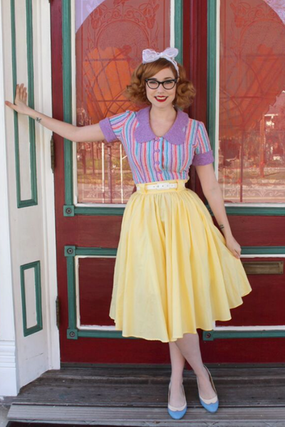 Model wearing Lil' Lou Lou's yellow Jivin' Skirt featuring a full gathered silhouette, belt loops, and pockets.