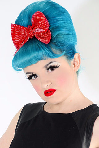 Model wearing Lil' Lou Lou Minnie Bow hair clip in red mini dot cotton fabric with vintage inspired beehive hairstyle