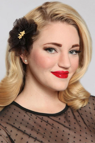 Blonde model wearing a black organza camellia hair flower clip for pin up, rockabilly and vintage inspired hairstyles.