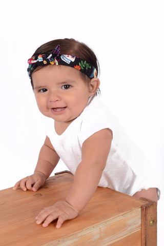 Baby wearing Lil' Lou Lou Colorful Skulls Mommy & Me Headband with soft elastic band and knotted bow detail.