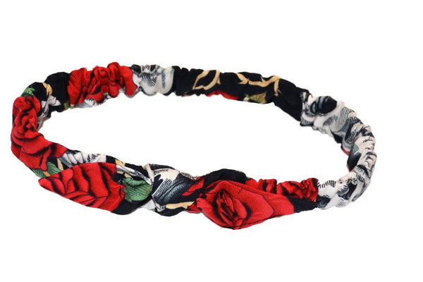 Vintage-inspired red skull and rose baby headband with elasticized back and knotted bow detail.