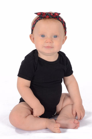 Baby wearing Lil' Lou Lou Sally Mommy & Me Headband featuring a red and black patchwork-inspired print with knotted bow detail.