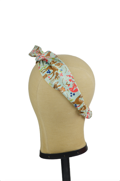 Princess of the Forest 4 in 1 headband shown on a mannequin head with woodland animals, trees, owls, and foxes print