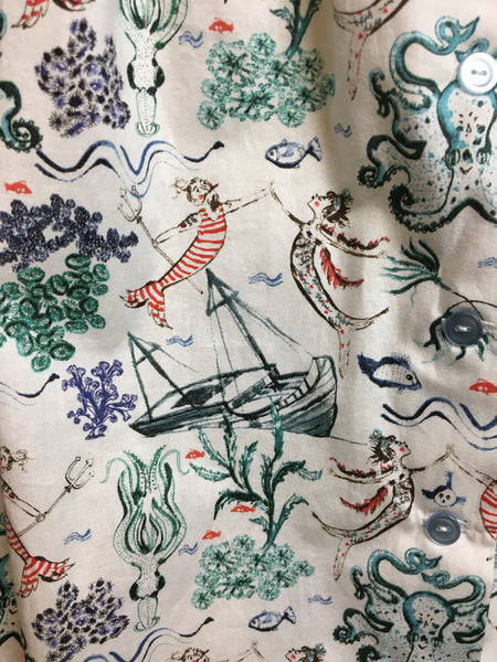 Close-up of the Mari Mar print featuring mermaids, octopus, sailboats, fish, and coral reefs
