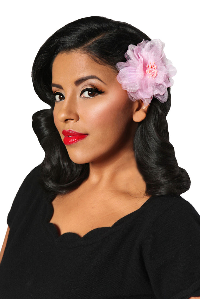 Model wearing a pink organza camellia hair flower clip for pin up, rockabilly and vintage inspired hairstyles.