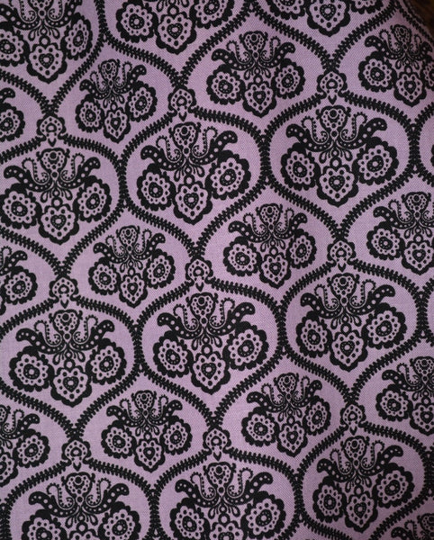 Close-up of the Haunting Wallpaper Jivin' Skirt fabric featuring a purple and black gothic wallpaper-inspired print designed for Lil' Lou Lou.