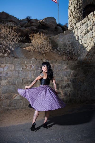 Model twirling in the Haunting Wallpaper Jivin' Skirt by Lil' Lou Lou, showcasing the full gathered silhouette and gothic-inspired print near a stone castle backdrop.