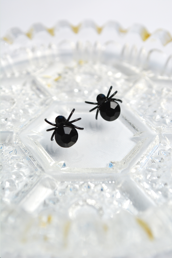 Black House Spider stud earrings displayed on a vintage crystal dish. Gothic spider earrings inspired by Lil' Lou Lou's Morticia's Garden collection.