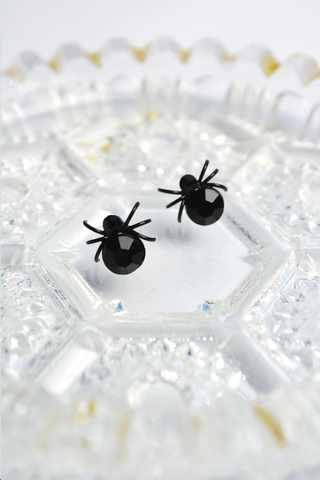 Black House Spider stud earrings displayed on a vintage crystal dish. Gothic spider earrings inspired by Lil' Lou Lou's Morticia's Garden collection.