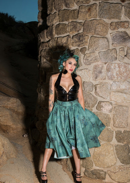 Model wearing the Morticia's Garden Green Jivin' Skirt by Lil' Lou Lou featuring a gothic floral print, full circle silhouette, and deep pockets.