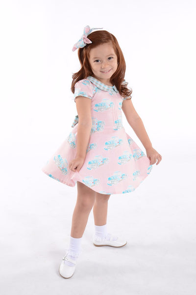 Little girl wearing Lil' Lou Lou Melly Dress in pink Classic Truck print with Peter Pan collar and vintage-inspired twirl skirt