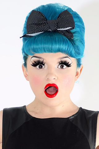 Model wearing Lil' Lou Lou Minnie Bow Hair Clip in Black Mini Dot cotton fabric with a retro pin up inspired hairstyle