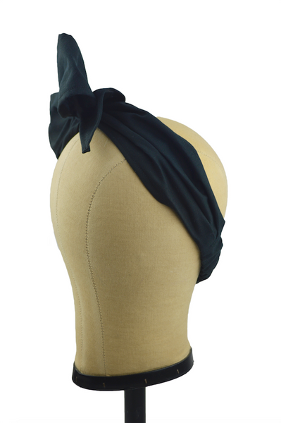 Side view of black Minnie Headband with oversized bow displayed on a mannequin head, vintage-inspired cotton hair scarf headband by Lil' Lou Lou.