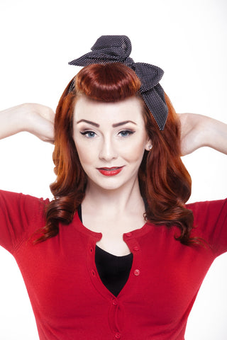 Model wearing Lil' Lou Lou Minnie Headband in black and white mini dot cotton, featuring an oversized bow and vintage-inspired pre-tied hair scarf design.