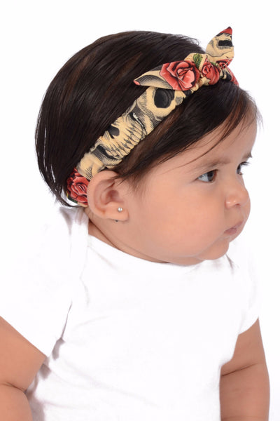 Baby wearing Beige Skull Roses Mommy & Me Headband featuring skull and rose print with knotted bow detail