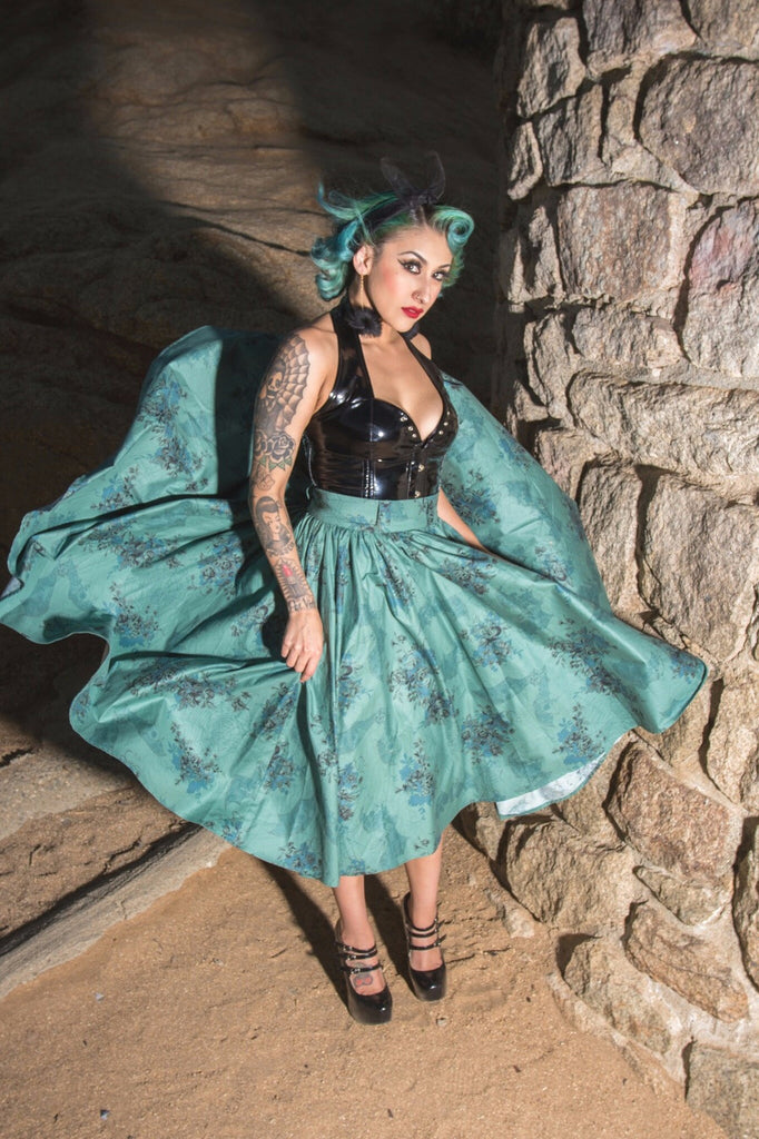 Model wearing the Morticia's Garden Green Jivin' Skirt by Lil' Lou Lou, a vintage-inspired full circle skirt with gothic floral print.
