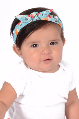 Baby wearing Lil' Lou Lou Sherry Mommy & Me Headband featuring an aqua novelty print and knotted bow detail.