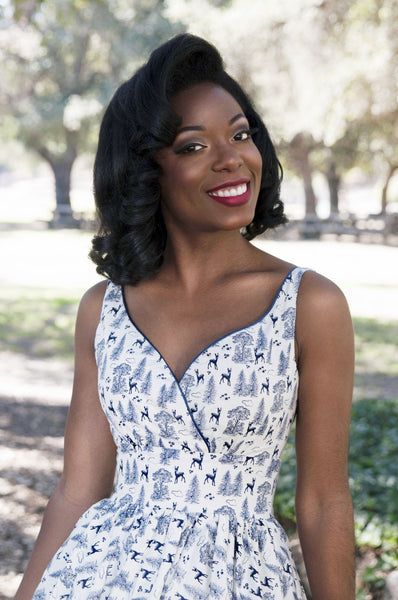 Model wearing the Razzle Dazzle Dress in ivory and navy woodland print featuring a fitted bodice, defined waist, and vintage-inspired neckline.
