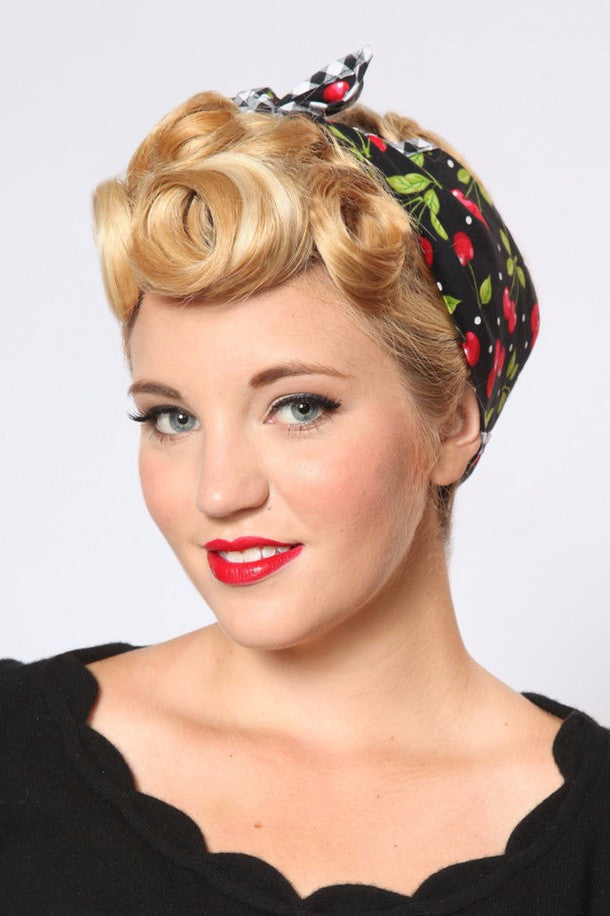 Model wearing the Black Cherry Dots Rosie Bandana featuring black cherry print and signature gingham trim styled with vintage pin curls.