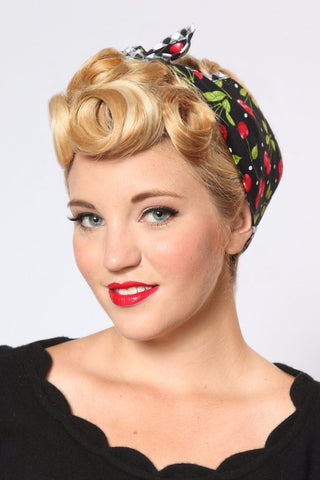 Model wearing the Black Cherry Dots Rosie Bandana featuring black cherry print and signature gingham trim styled with vintage pin curls.