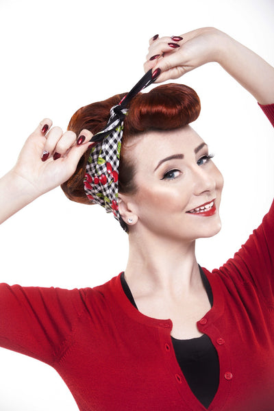 Model demonstrating the Cherry Picnic Rosie Bandana featuring cherry and gingham print styled with vintage bumper bangs.