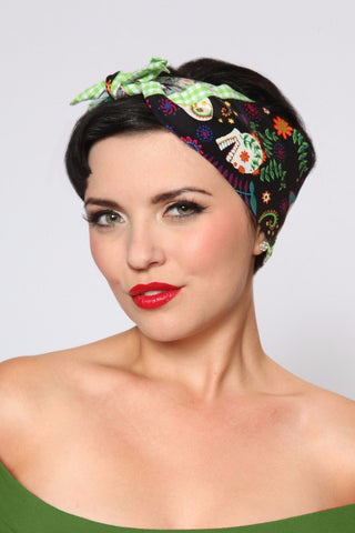 Model wearing the Colorful Skull Rosie Bandana featuring colorful skull print and green gingham ties.