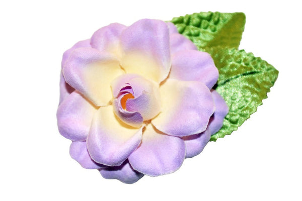Close-up of lilac Rosita hair flower with green leaves and soft textured petals.