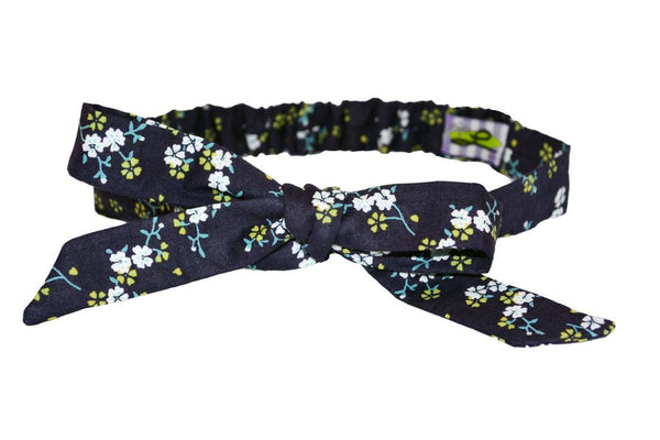 Wildflower Navy Tracy Headband featuring a navy floral print and adjustable bow styling inspired by vintage hairstyles.