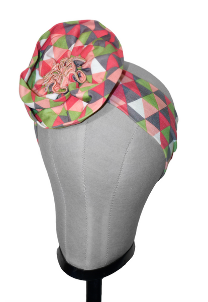 Triangle Pink pre-tied turban headband displayed on a mannequin featuring a geometric knit print and center flower detail.