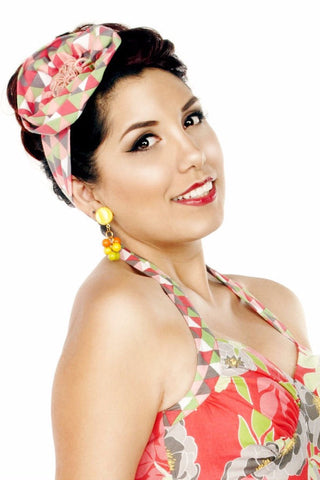 Model wearing the Triangle Pink Turban Headband styled with a vintage updo and tropical-inspired outfit.
